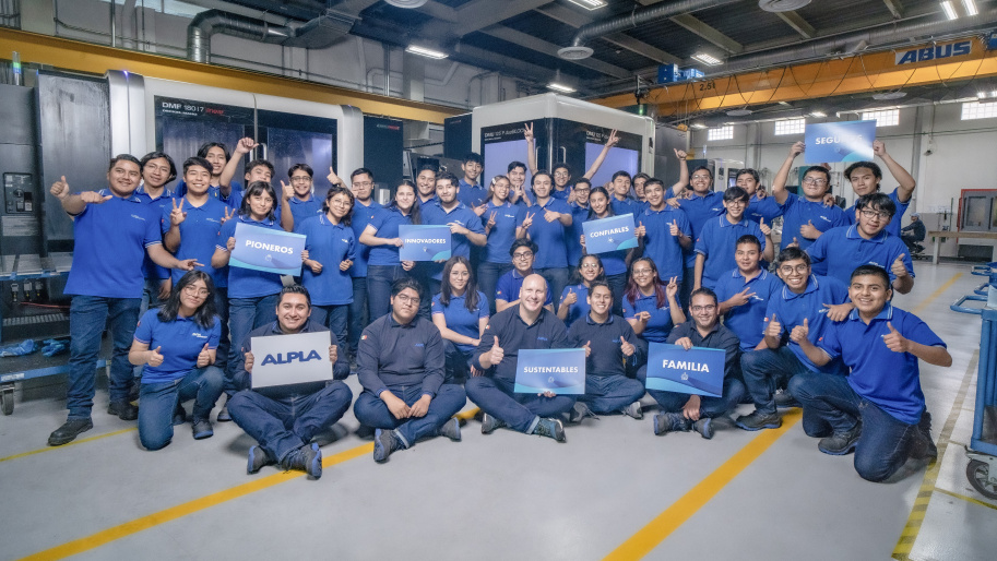 Group of ALPLA employees at a production site in Mexico standing together in a manufacturing hall, highlighting teamwork, engagement, and a positive workplace culture.