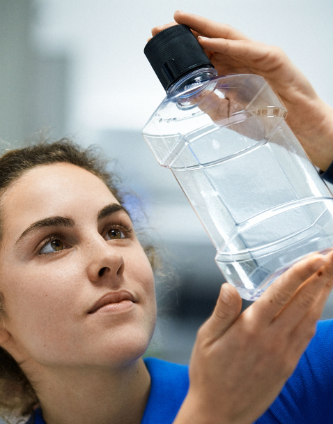 employee holds full service created bottle 